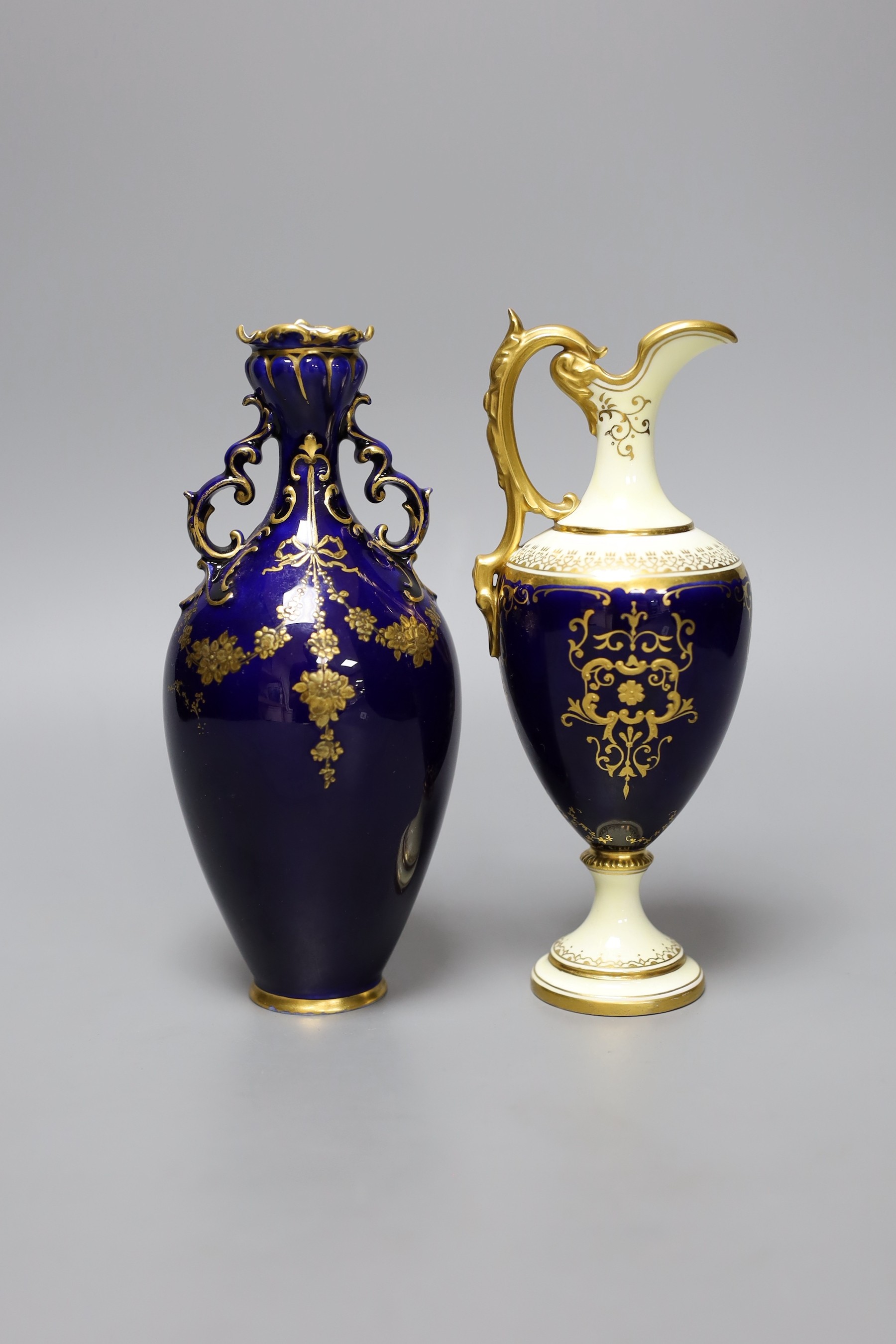 A Coalport blue ground ewer, with a gilded oval panel with a loch scene, c.1900, and a Royal Crown Derby vase with raised gilded decoration on a cobalt blue ground, date code 1898, tallest 18cm